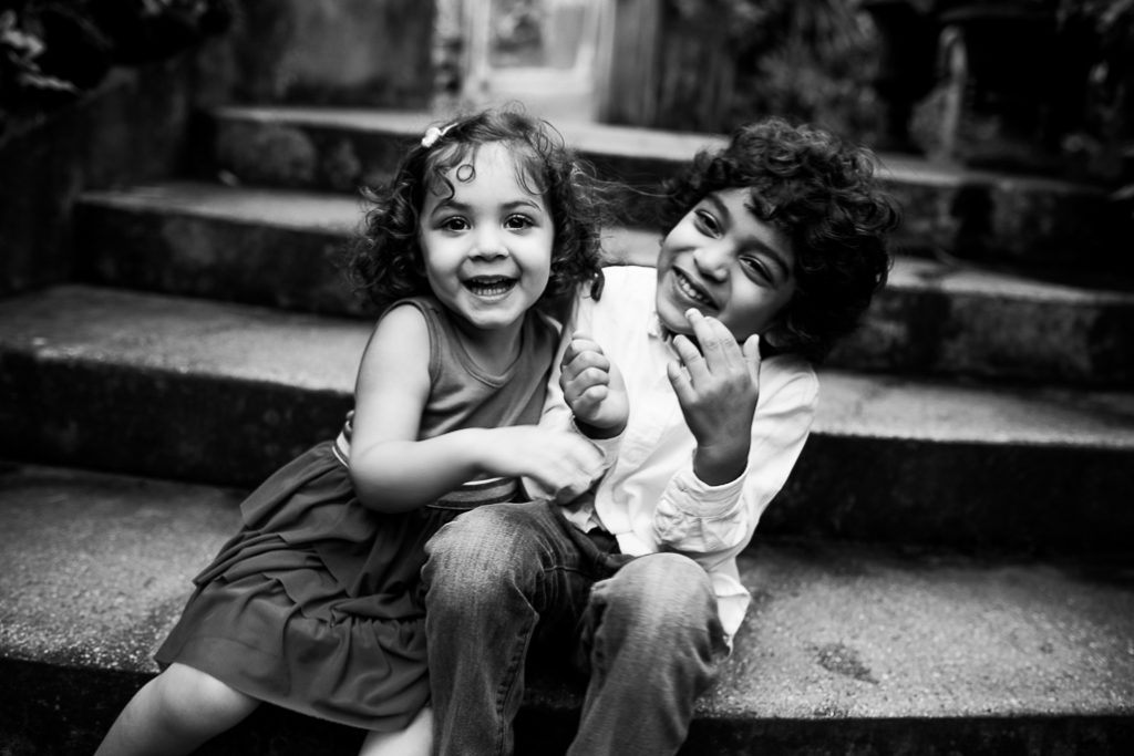 Kids laughing sitting on steps. Black and white photo