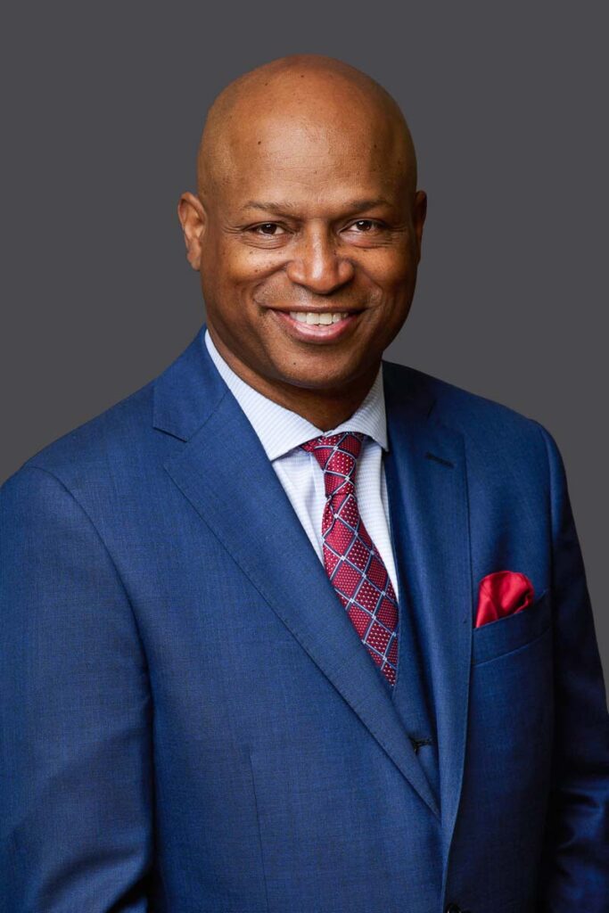Headshot of Male in blue jacket and red tie on dark grey backdrop taken by Rosemont Headshot Photographer Lisa Kay