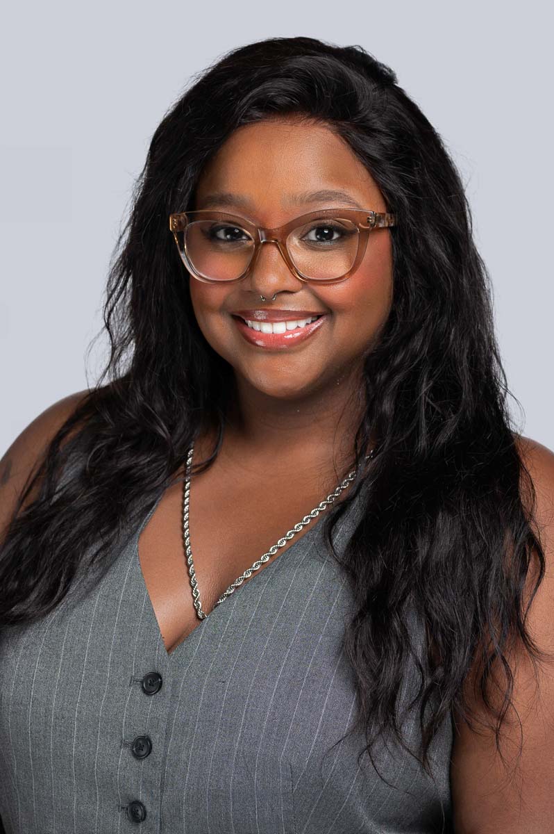 Professional Headshot of Women in Grey Vest with Red Glasses. Photo taken by Schaumburg Headshot Photographer Lisa Kay