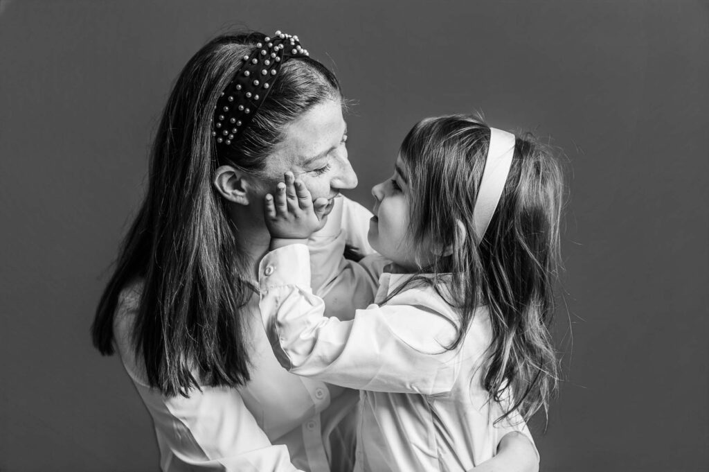 Mother with little girl holding her face