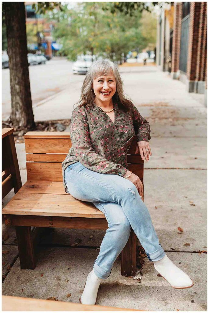 woman with grey hair sitting on bench outside