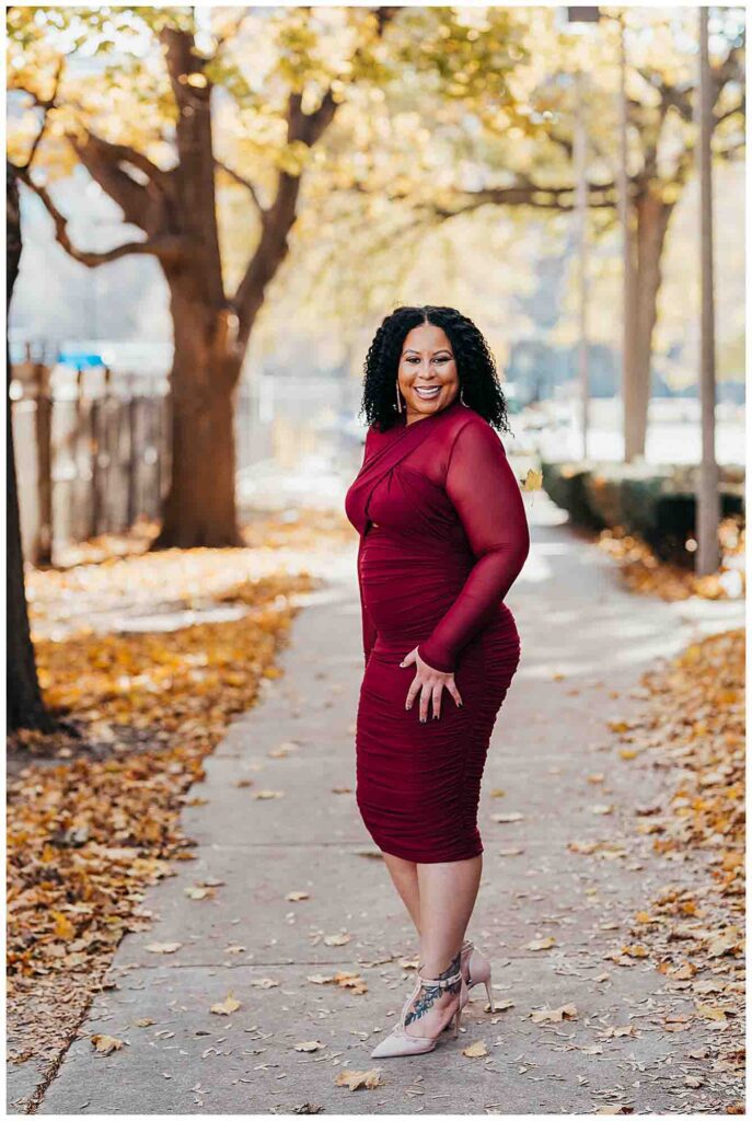 Woman smiling at camera in tight red dress in the fall